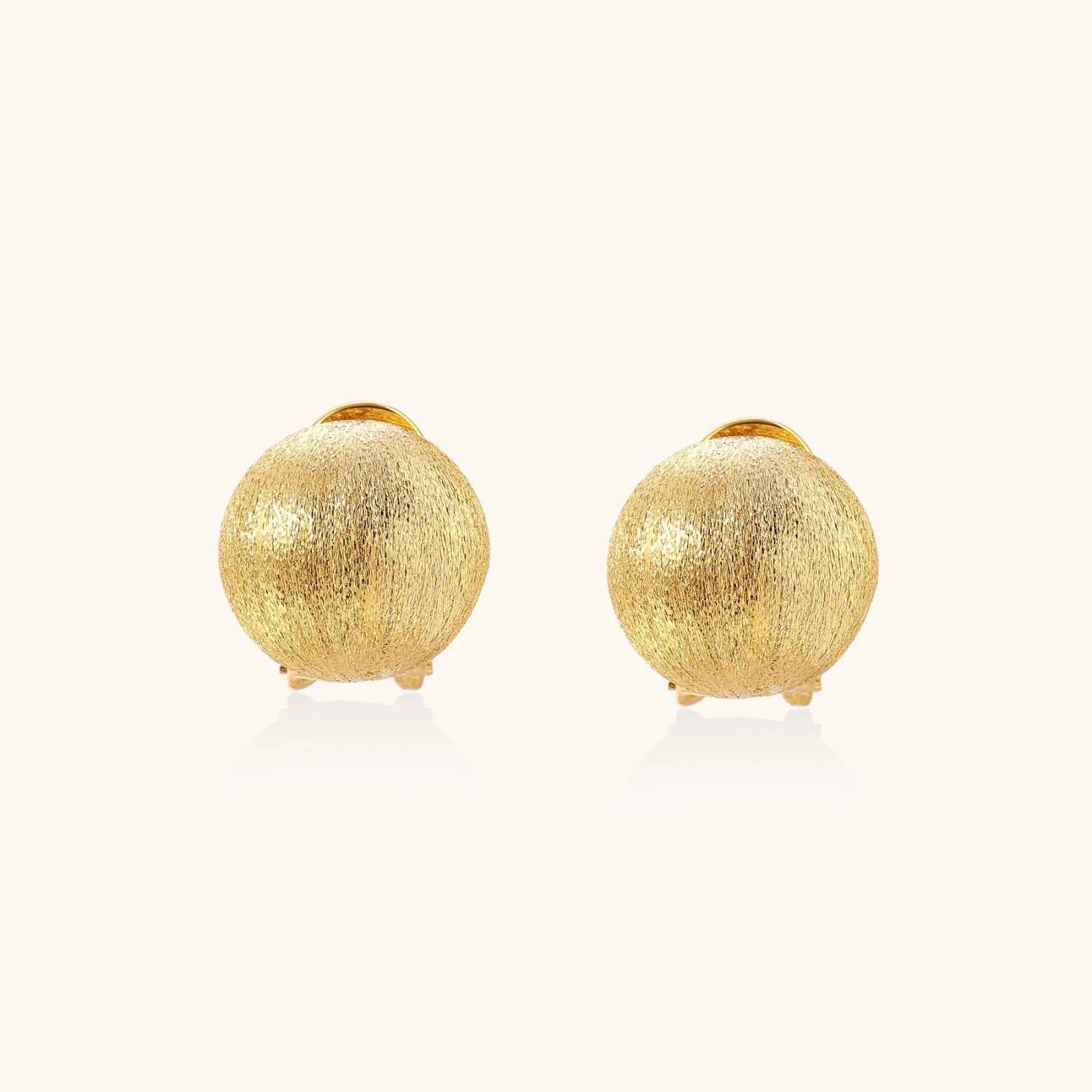Angled view of Brushed Gold Dome Clip Earrings by Averuna Jewellery