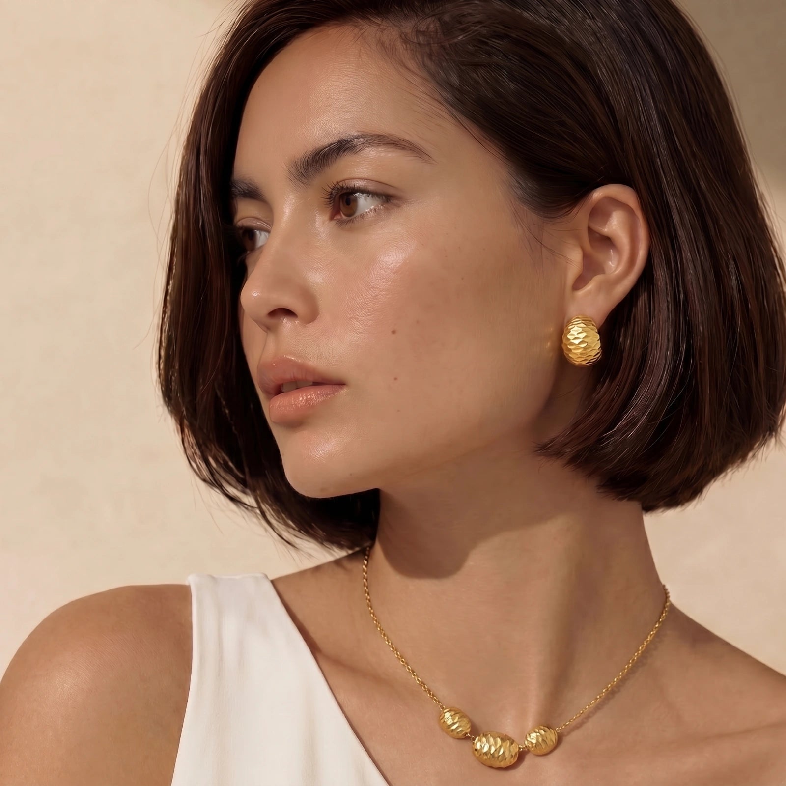 Lifestyle view of Hammered Gold Huggie Earrings by Averuna Jewellery